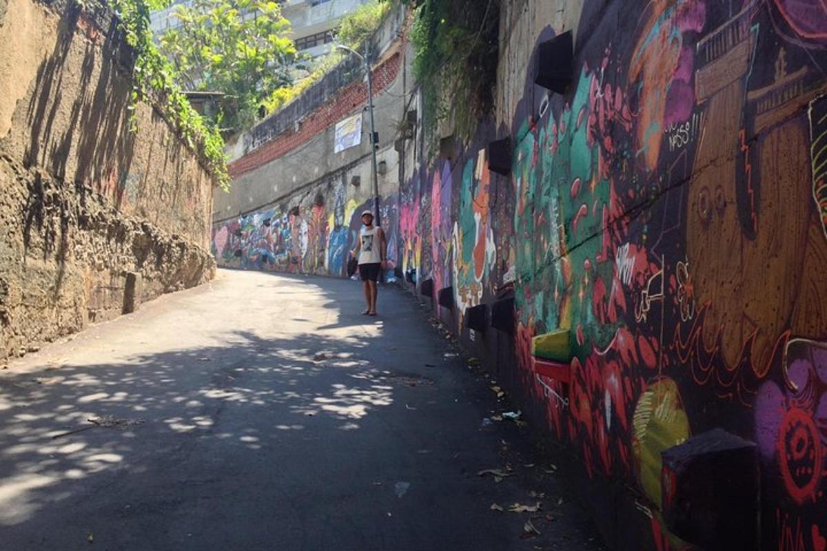 a person walking down a street next to a wall covered in graffiti