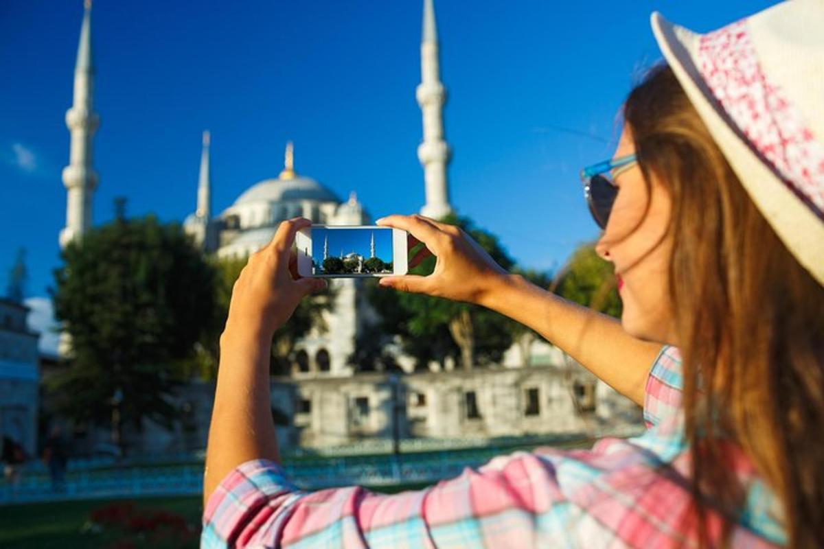 žena fotí mešitu mobilním telefonem