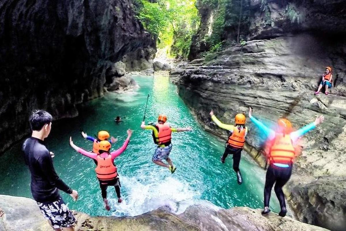 un grup de persones saltant d'un penya-segat a un riu