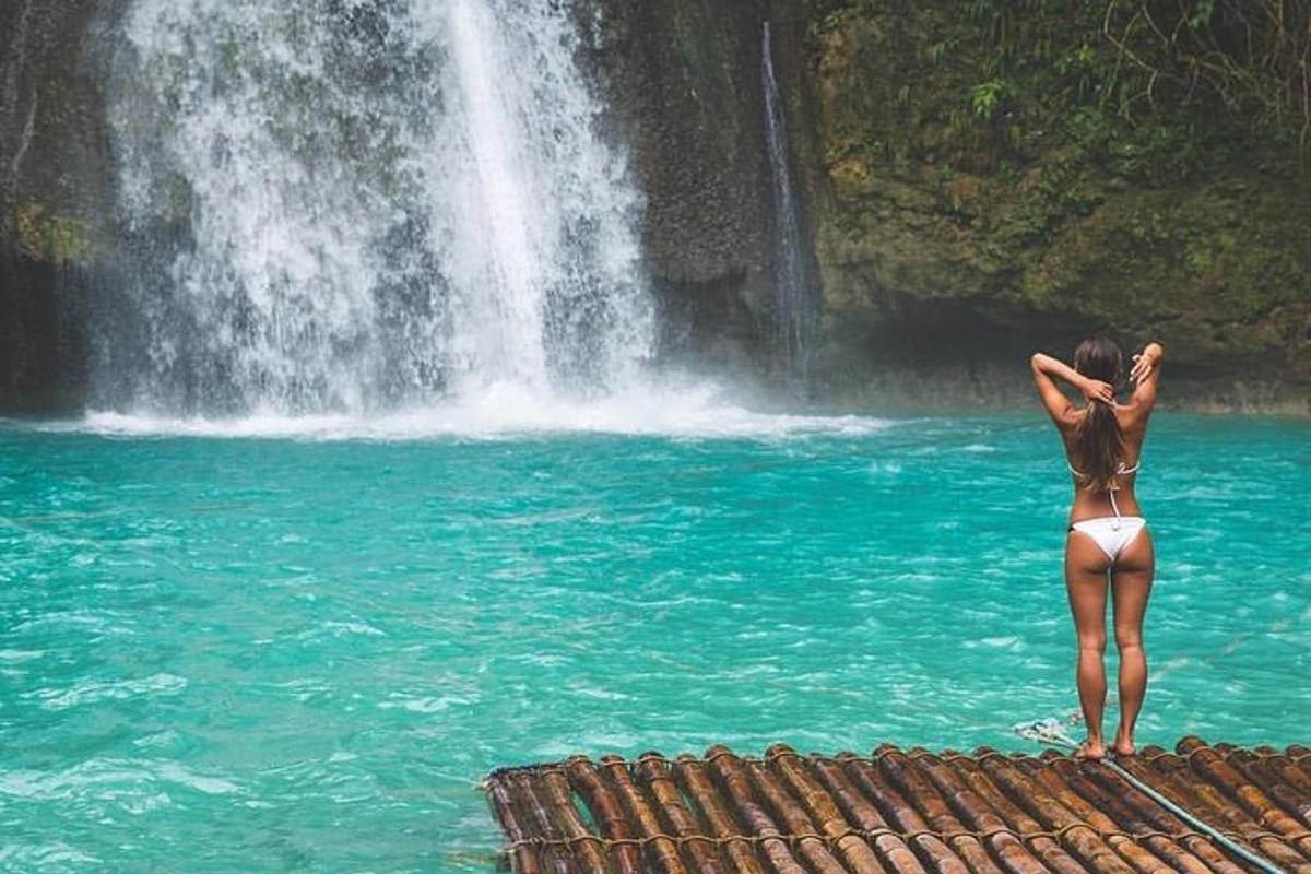 una dona dempeus a l'aigua prop d'una cascada