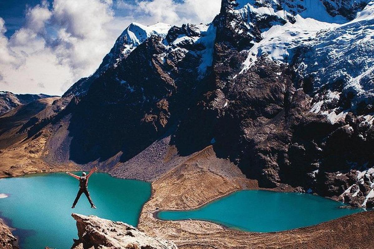 una persona che salta in aria sopra un lago di montagna