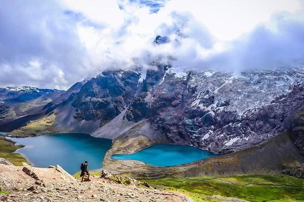 un uomo in piedi sulla cima di una montagna che domina un lago