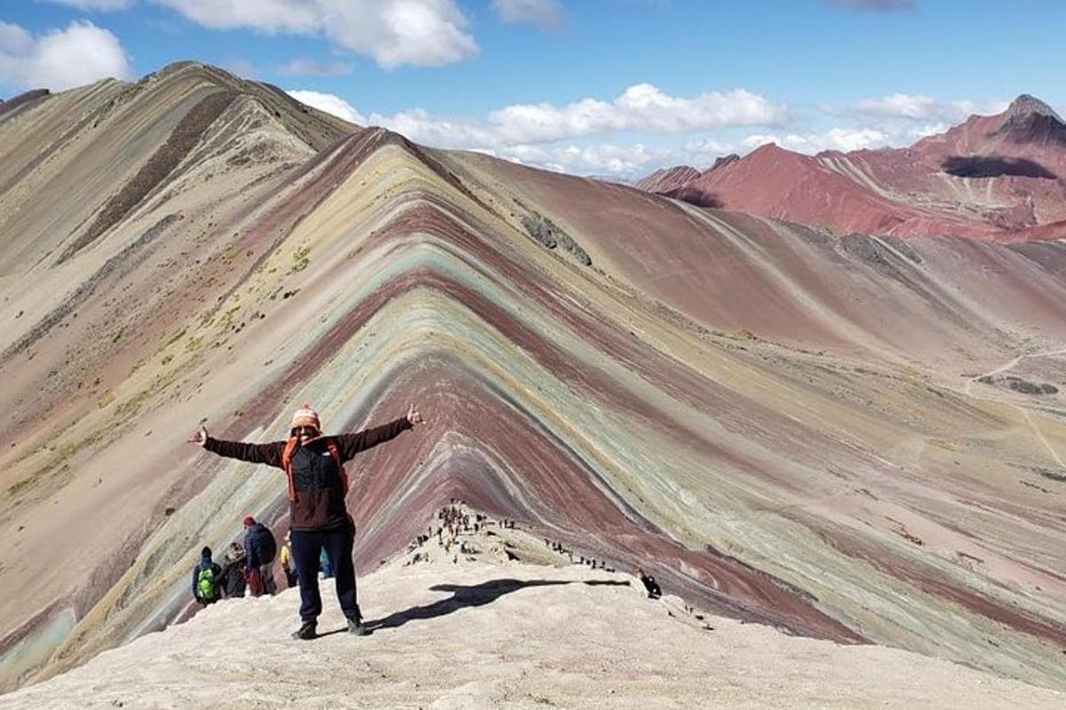 seorang lelaki berdiri di atas gunung dengan tangan dihulurkan
