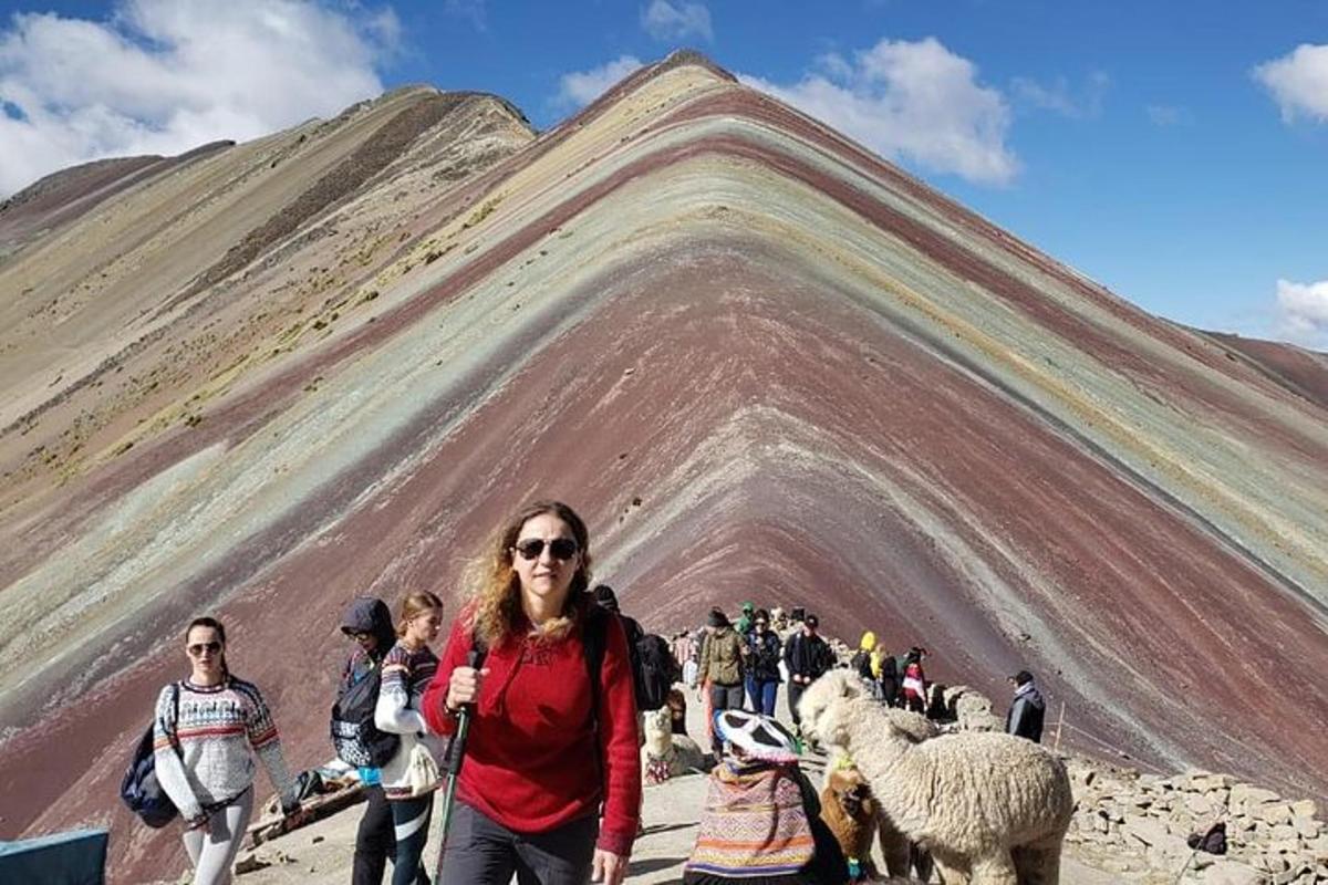 eine Frau steht vor einem Berg mit Schafen