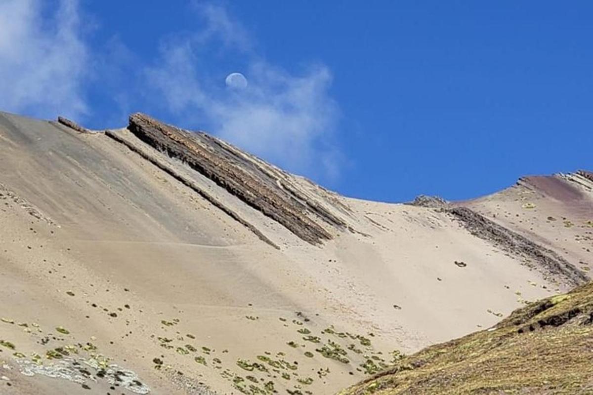 ein Sandhügel mit dem Mond am Himmel