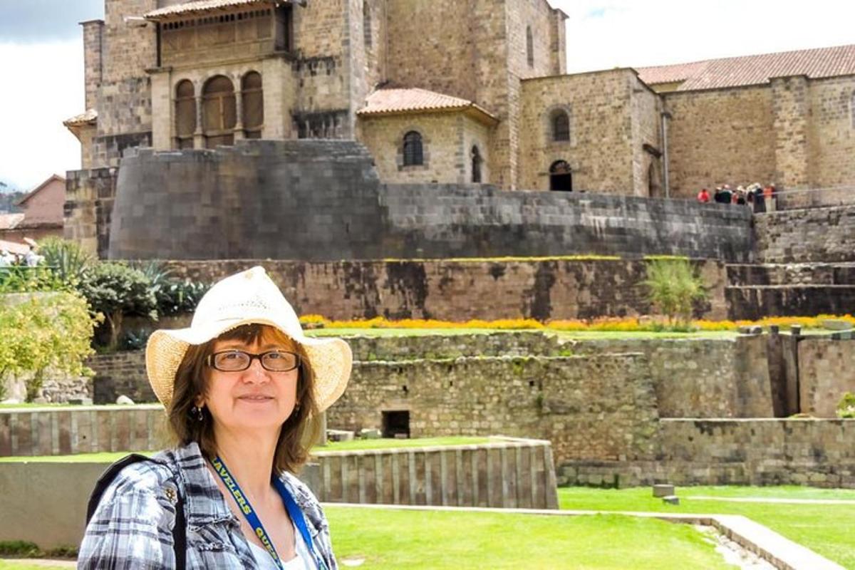 o femeie cu pălărie stând în fața unui castel