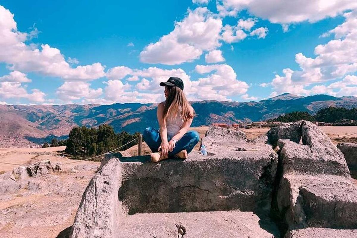 uma mulher sentada na beira de uma montanha