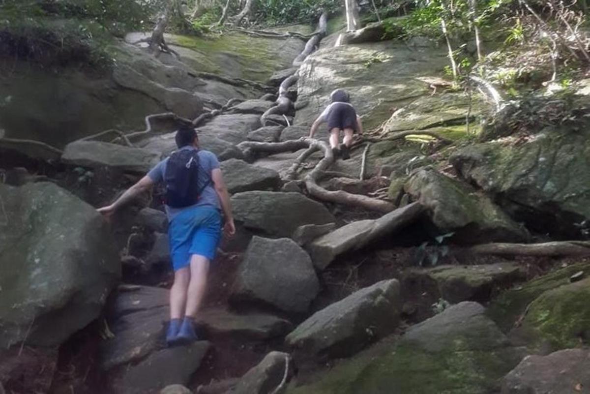 duas pessoas caminhando por uma trilha rochosa