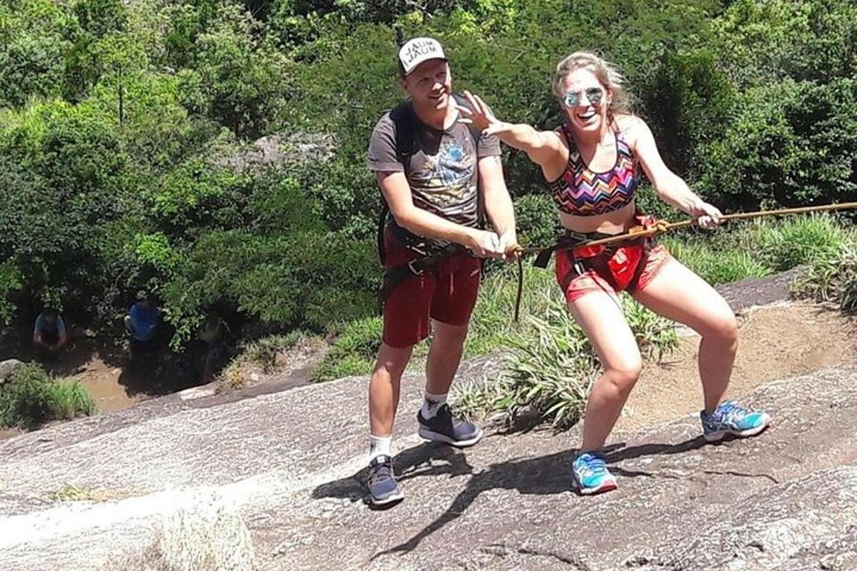 um homem e uma mulher em pé sobre uma rocha