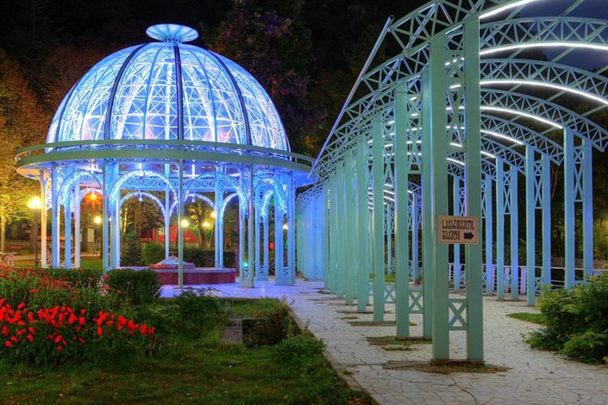 egy kék épület pavilonnal a kertben éjszaka