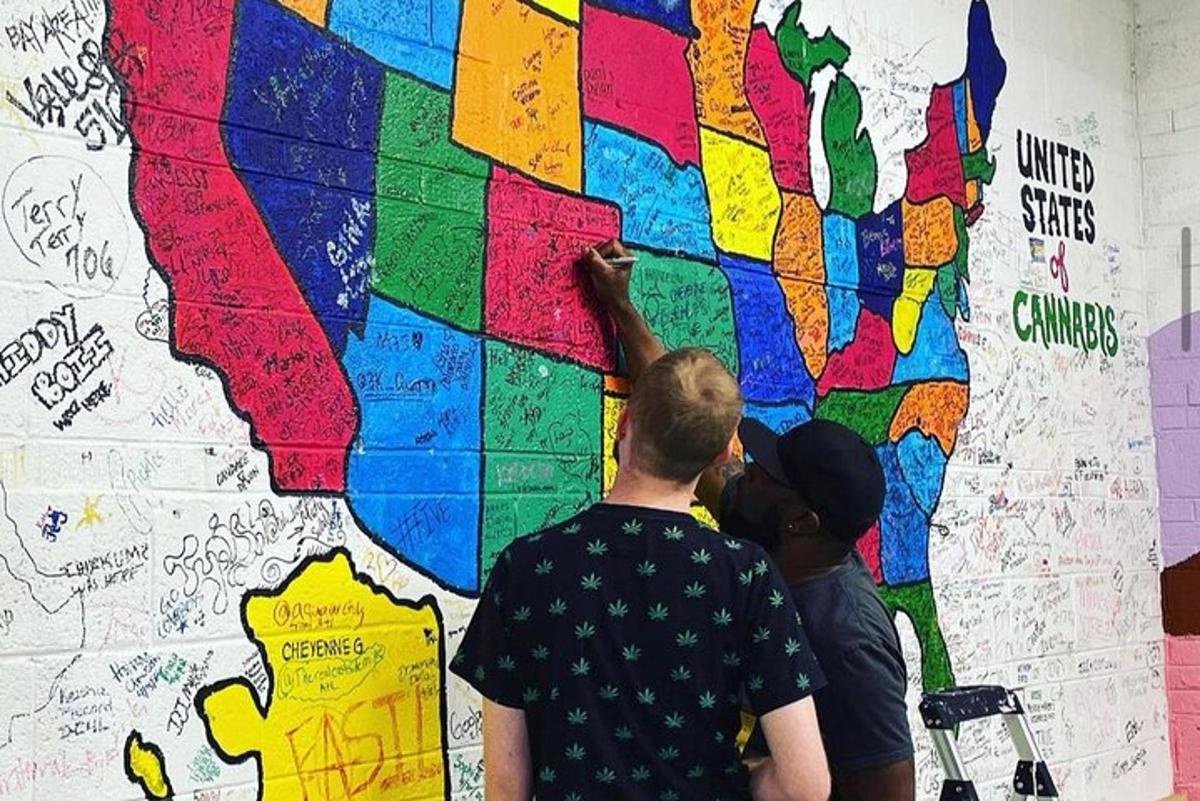 two people painting a mural on a wall