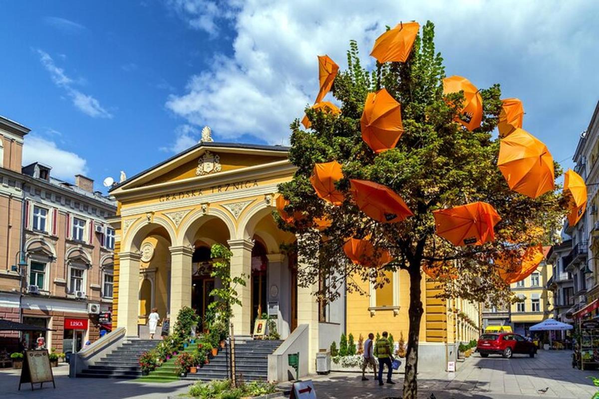 un edificio giallo con ombrelli arancioni appesi a un albero