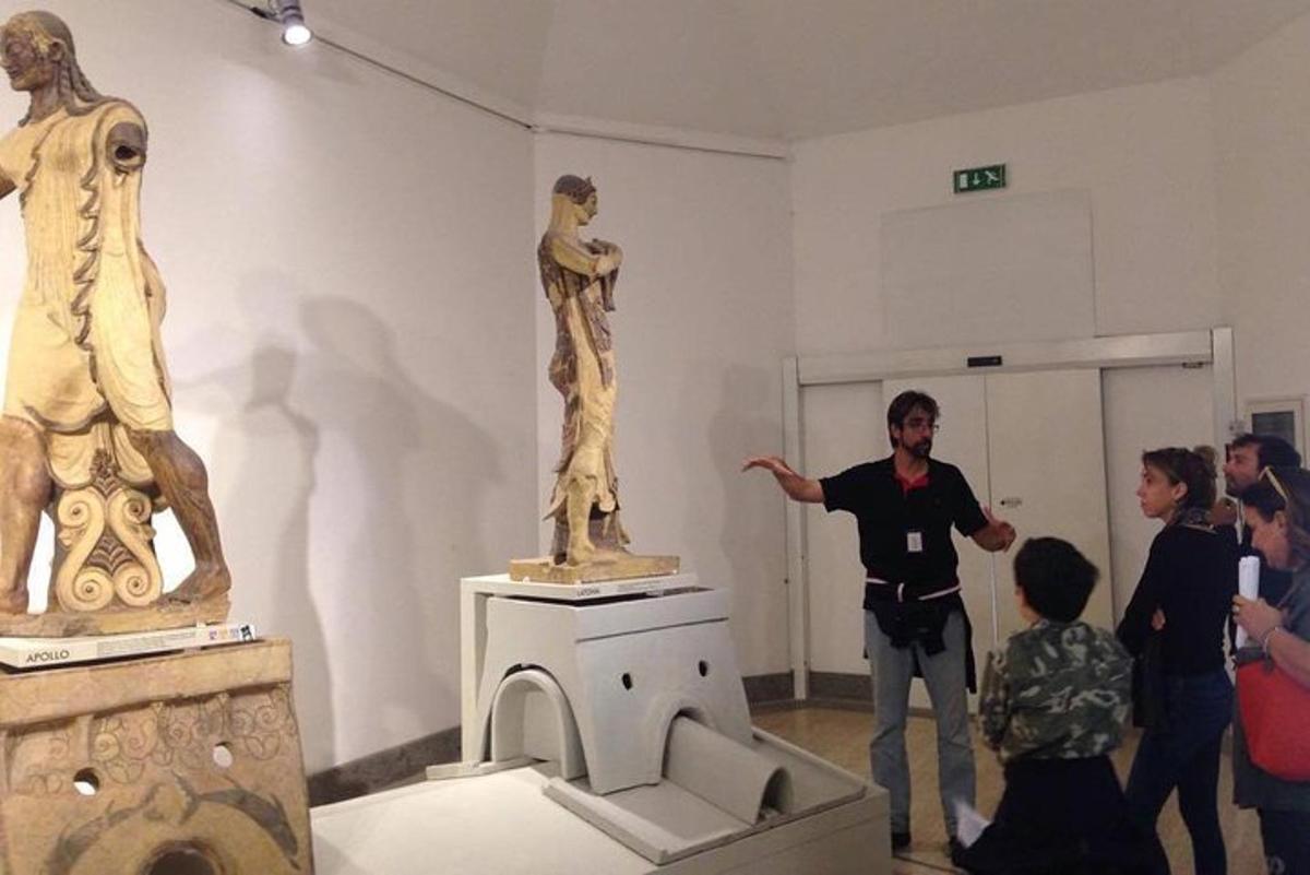 a group of people looking at a statue in a museum