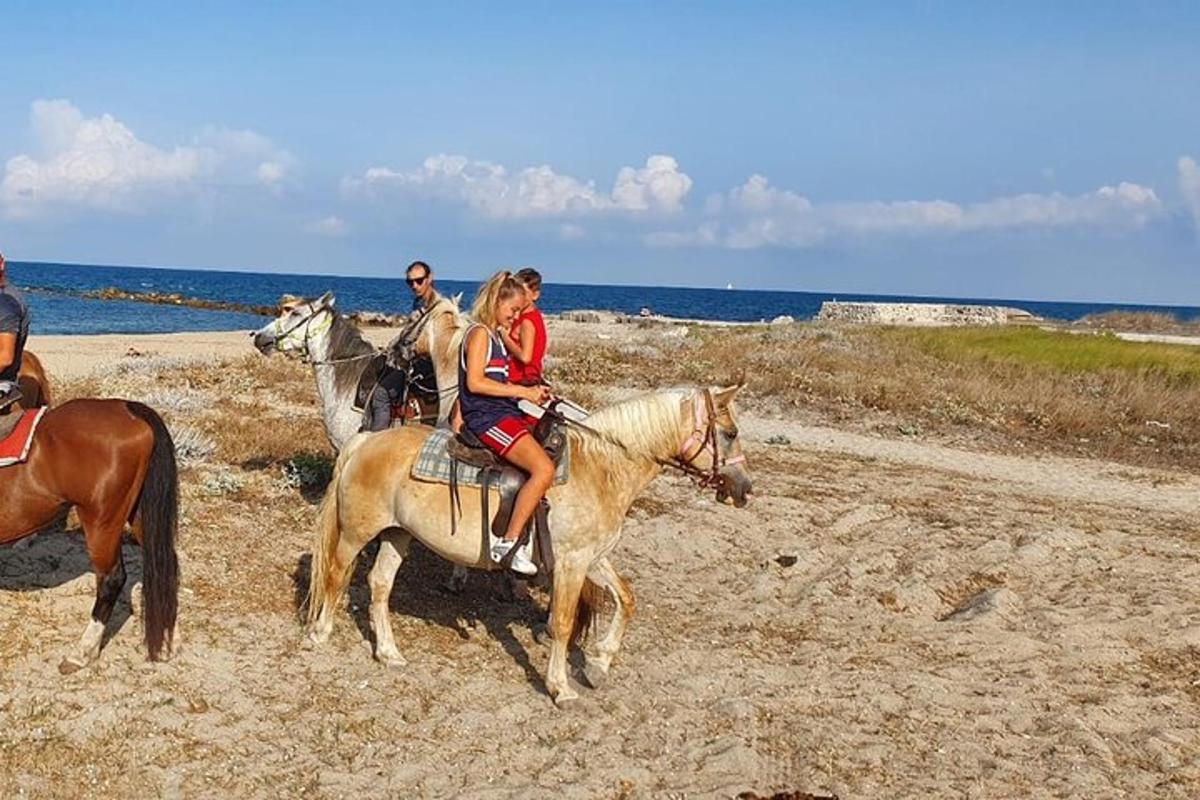 um grupo de pessoas andando a cavalo na praia
