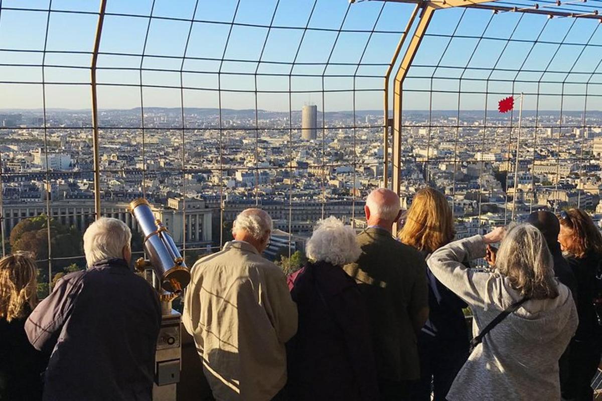 a group of people looking at the city from the eiffel tower