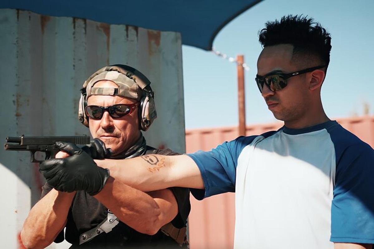 seorang lelaki memegang pistol dan seorang lagi lelaki memakai fon kepala