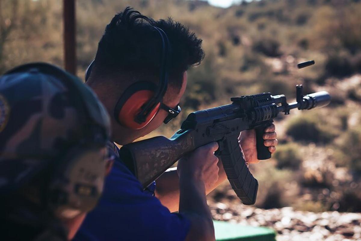 seorang lelaki memegang pistol di hadapan seorang wanita