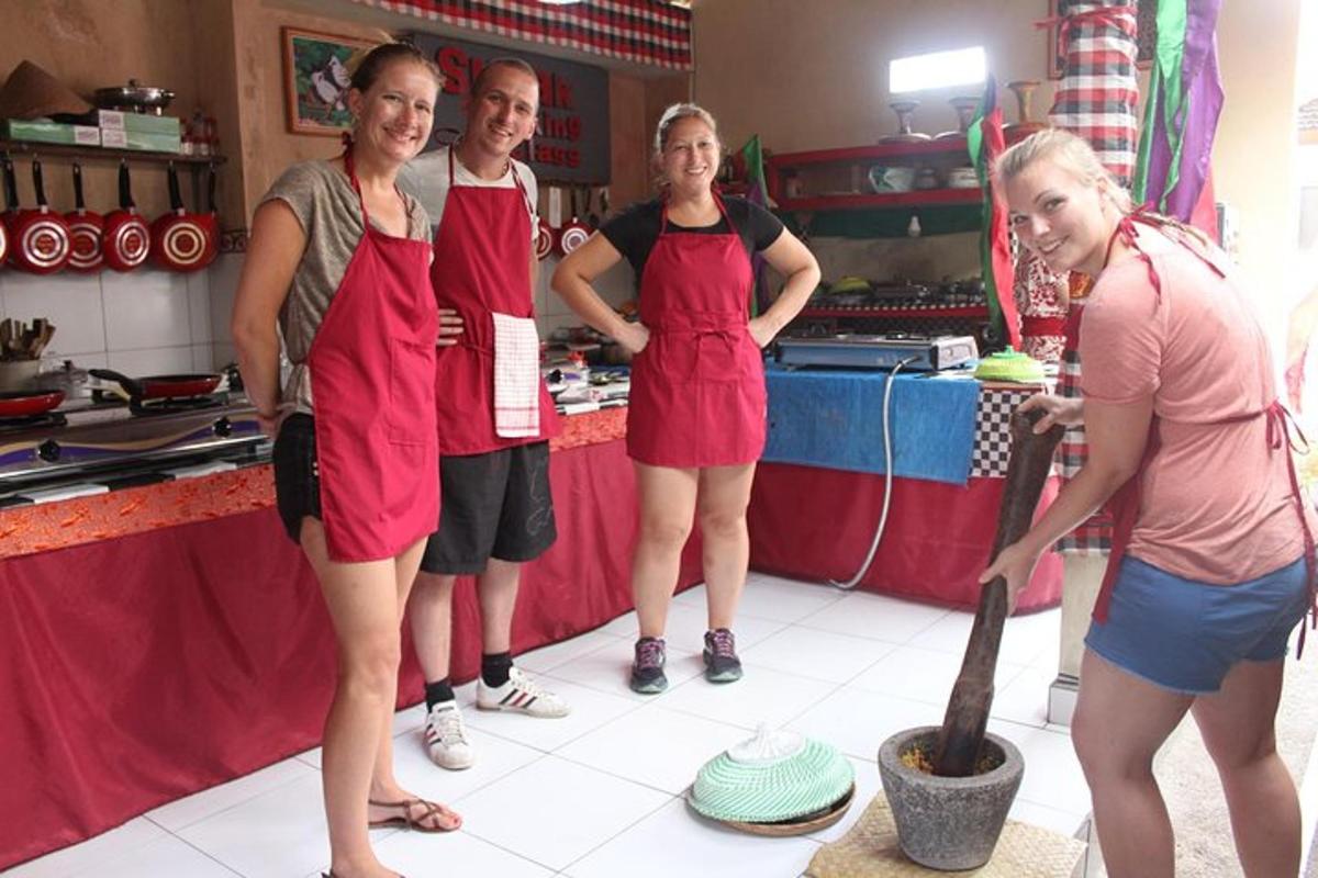 a group of women wearing red aprons in a kitchen