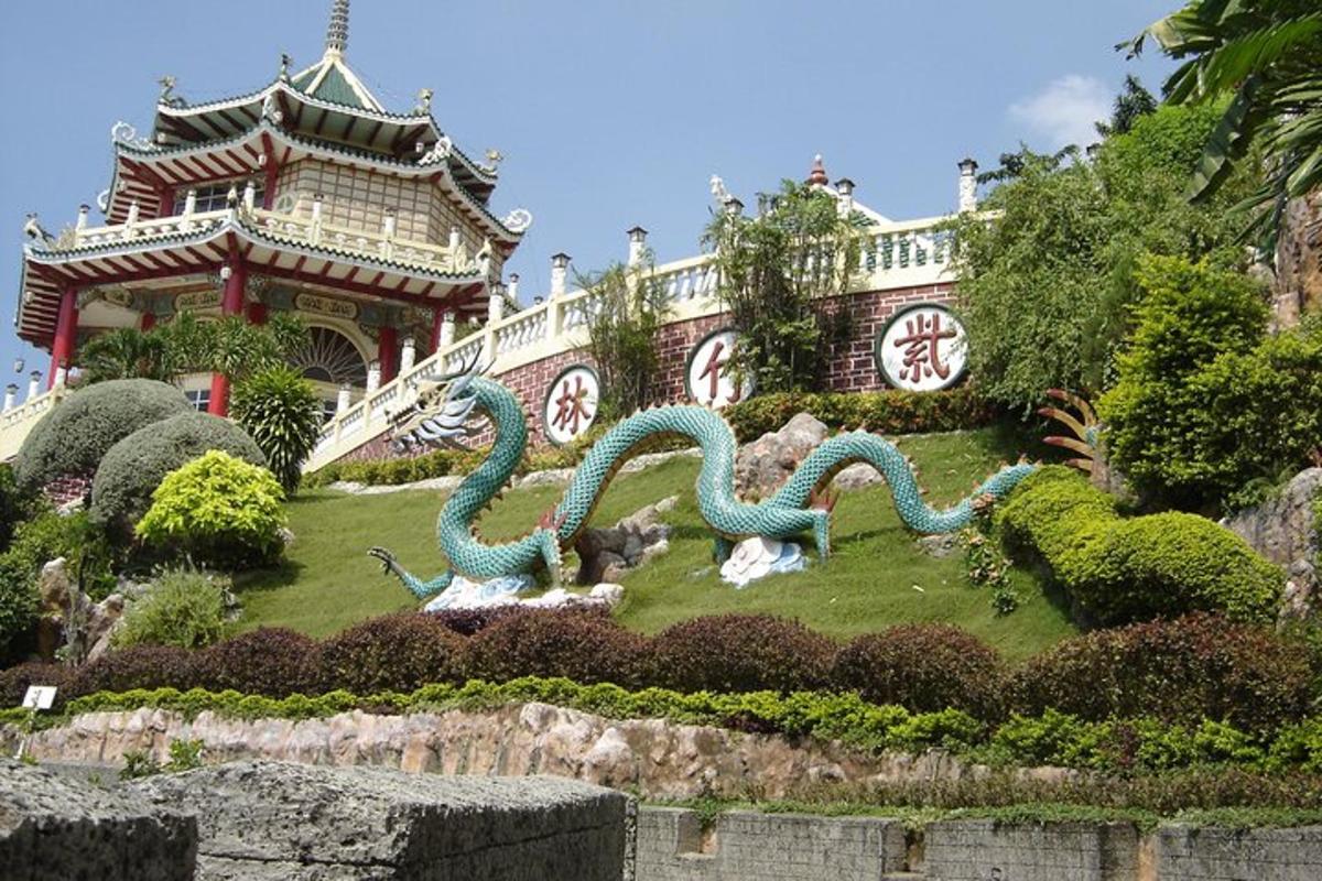 a garden with two dragon statues in front of a building