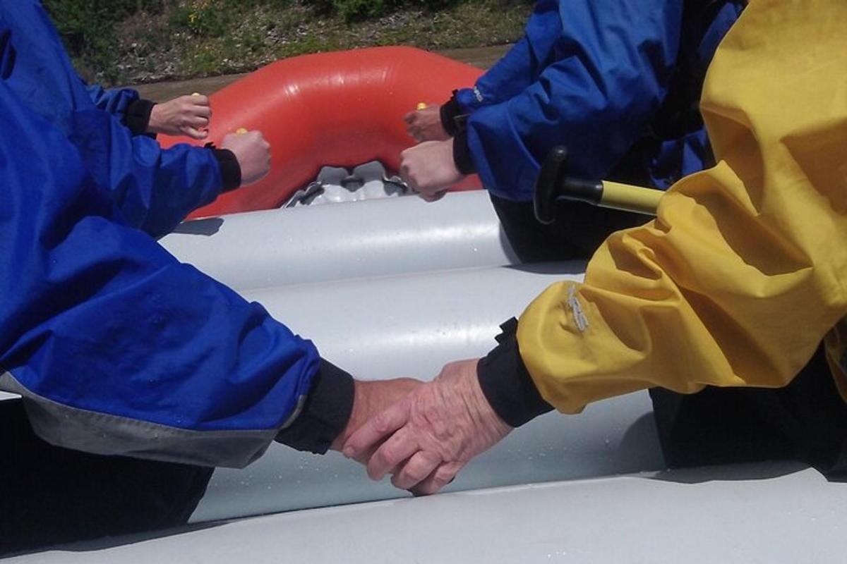 Dos personas se toman de la mano en una balsa inflable.