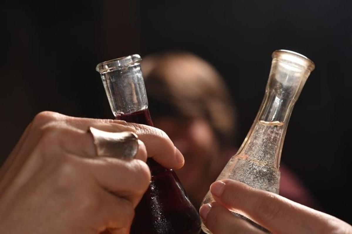 Dos personas sostienen botellas de cerveza.