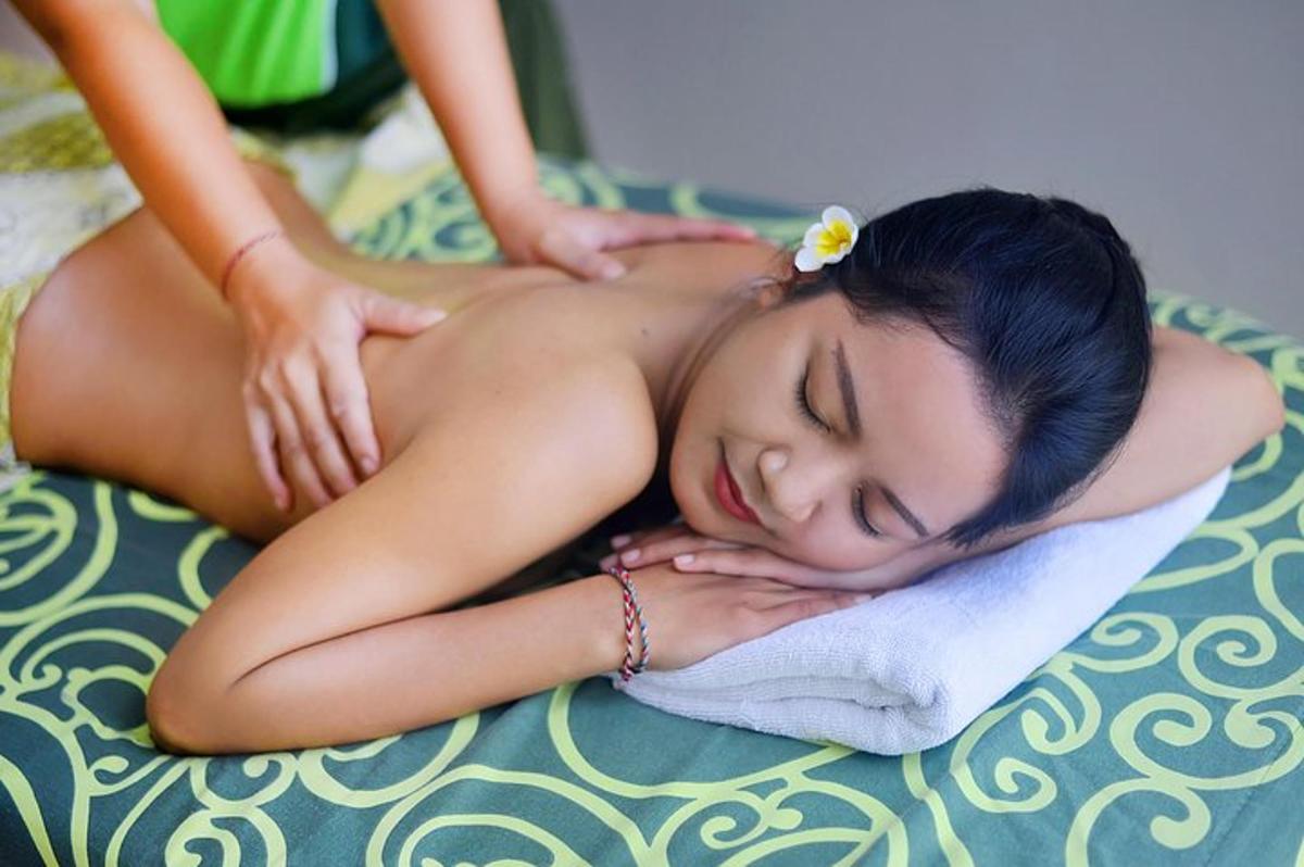 a young woman getting a back massage on a bed