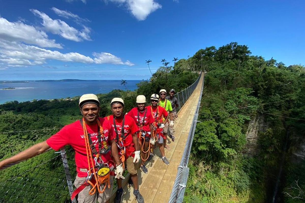 a group of men standing on a suspension bridge over a cliff