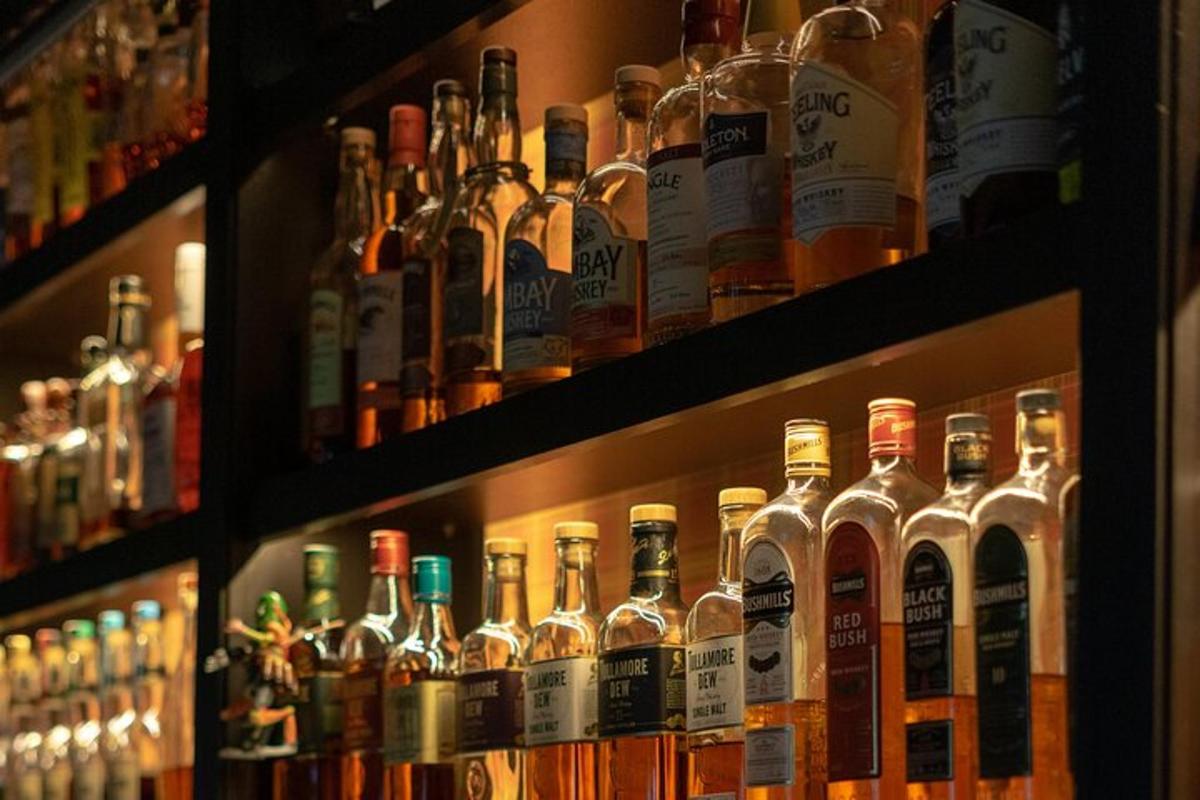 Röð af áfengisflöskum á hillum í bar