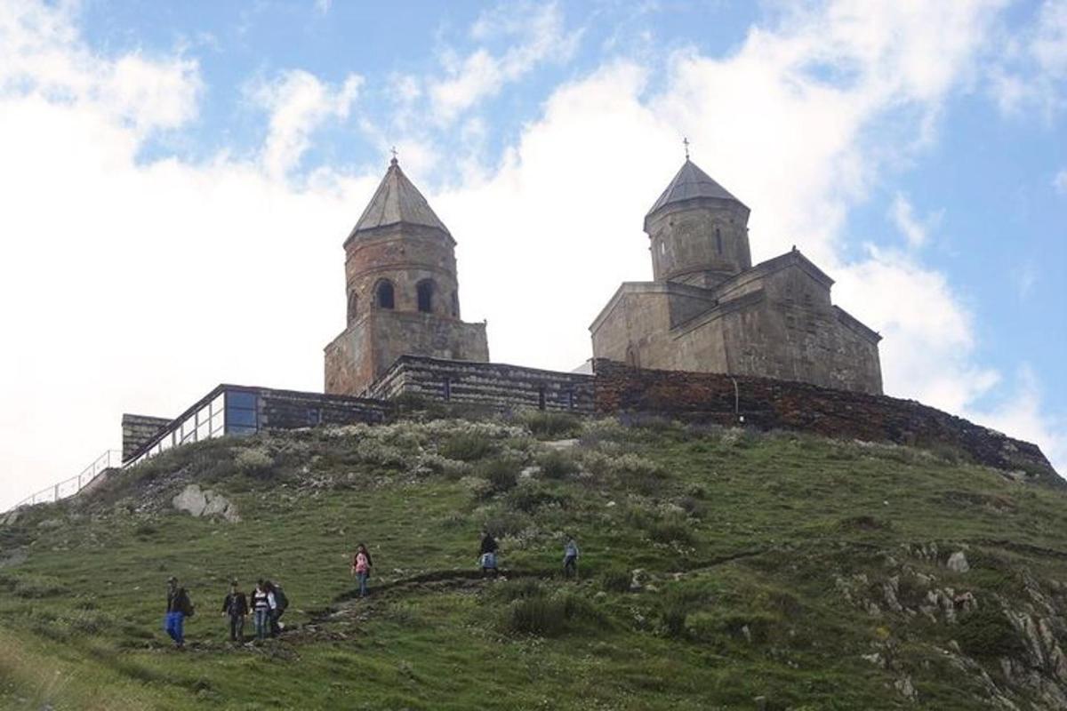 eine Gruppe von Menschen steht auf einem Hügel mit einer Burg