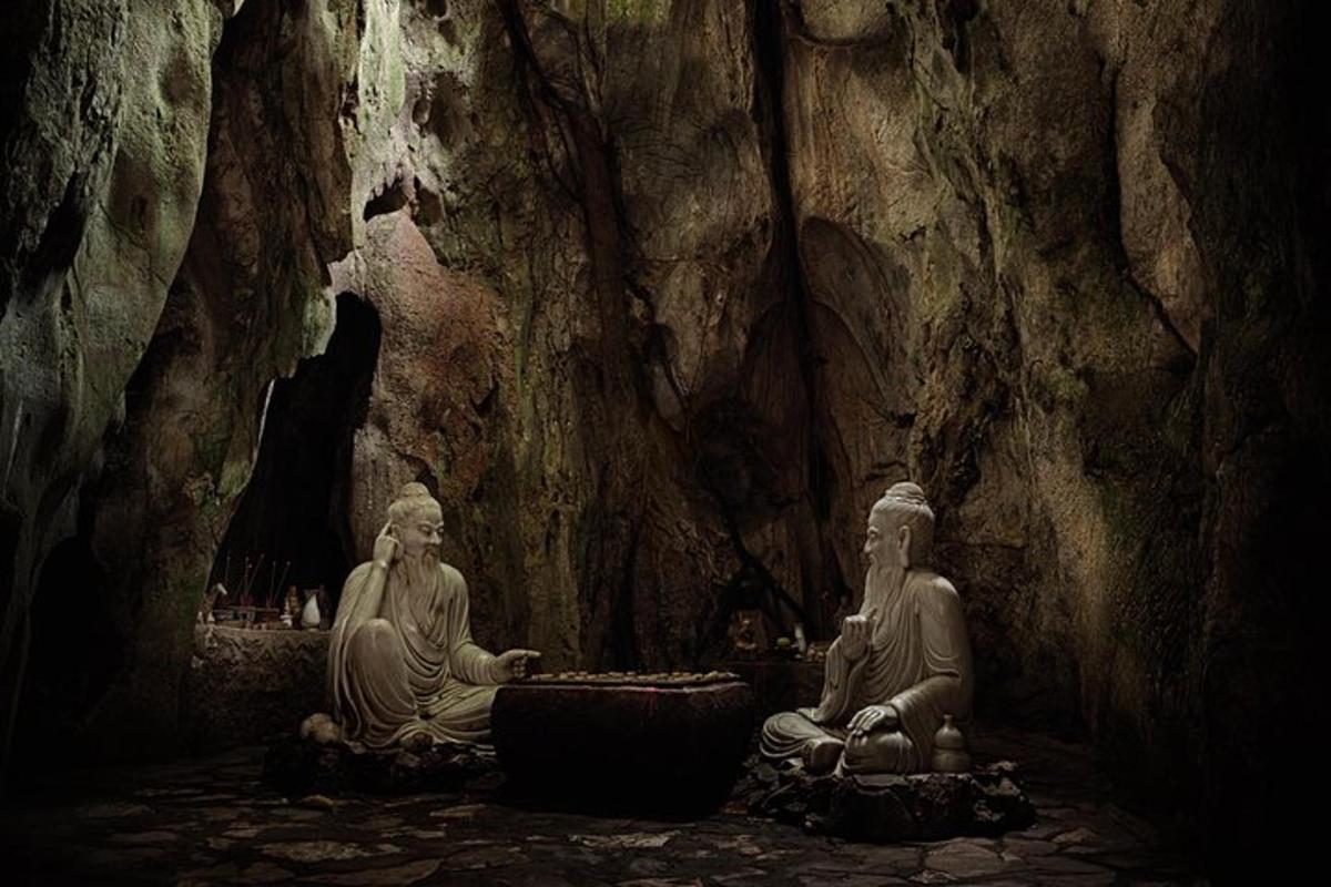 duas estátuas de monges sentados em uma caverna