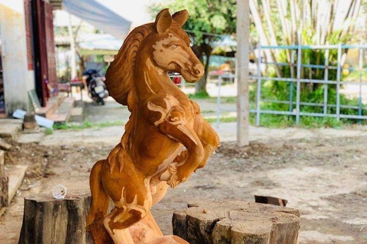 drevená socha koňa sediaca na vrchole pňa