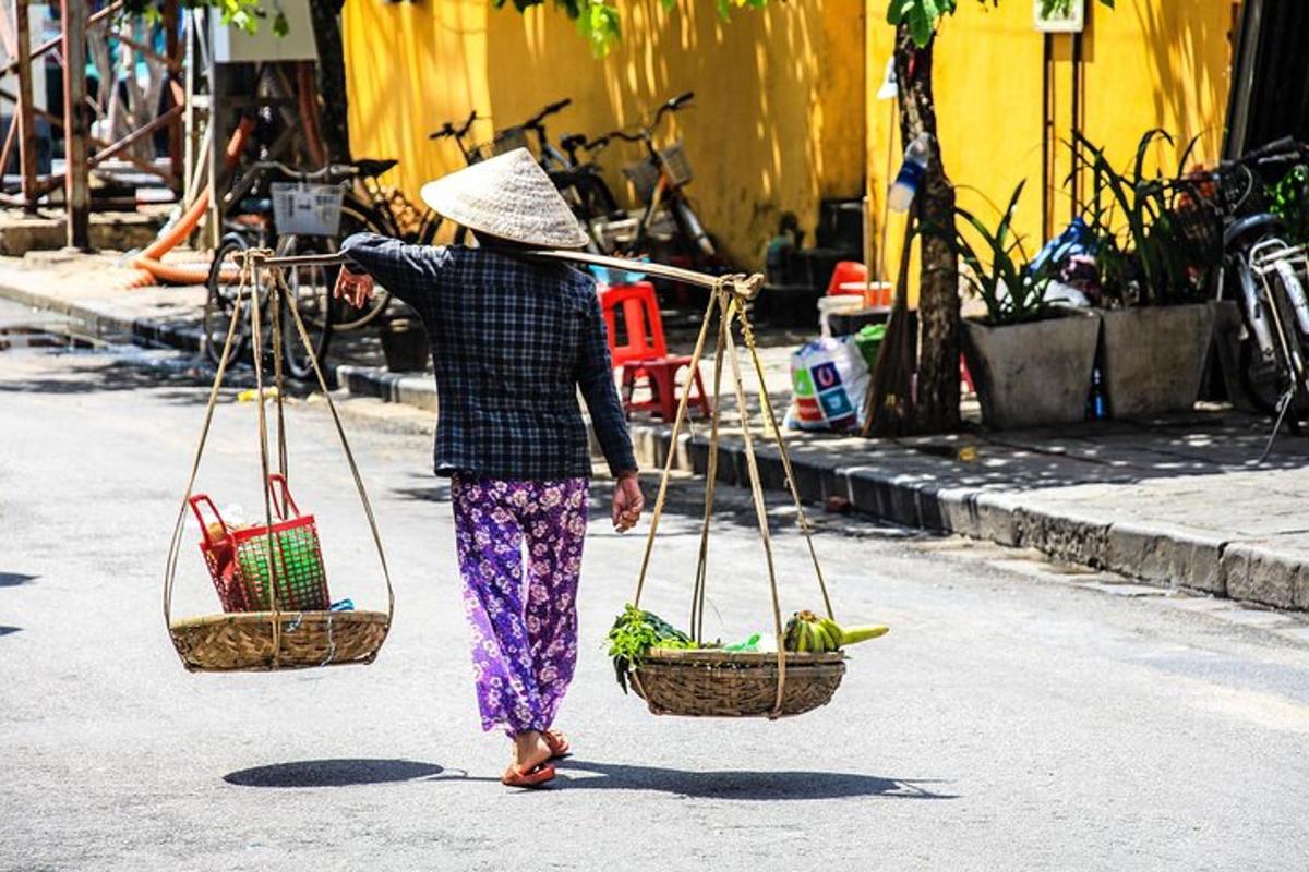 una donna che cammina per strada portando dei cestini