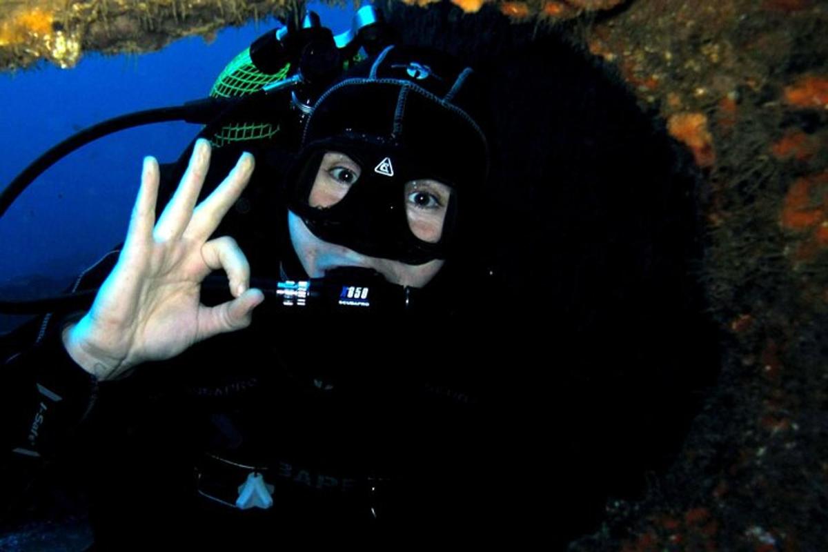 a person in a diving mask holding up their hand