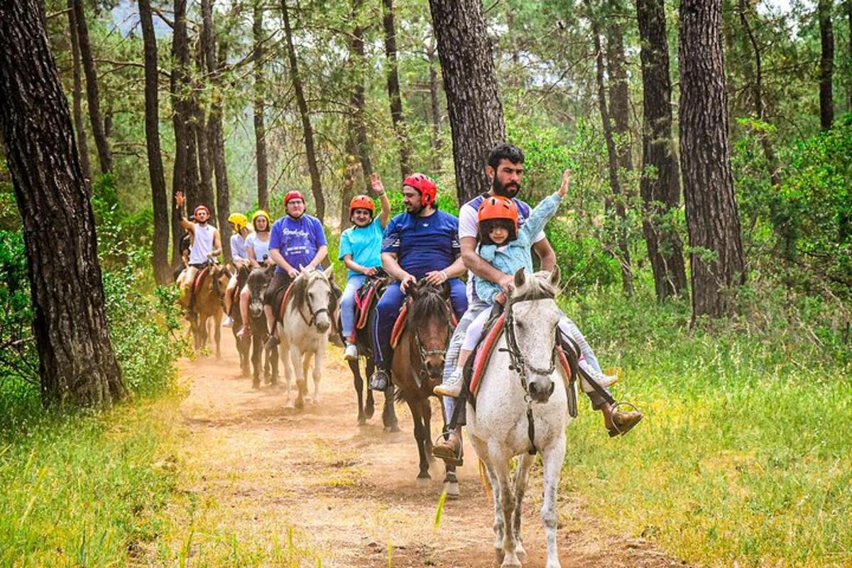a group of people riding horses on a trail