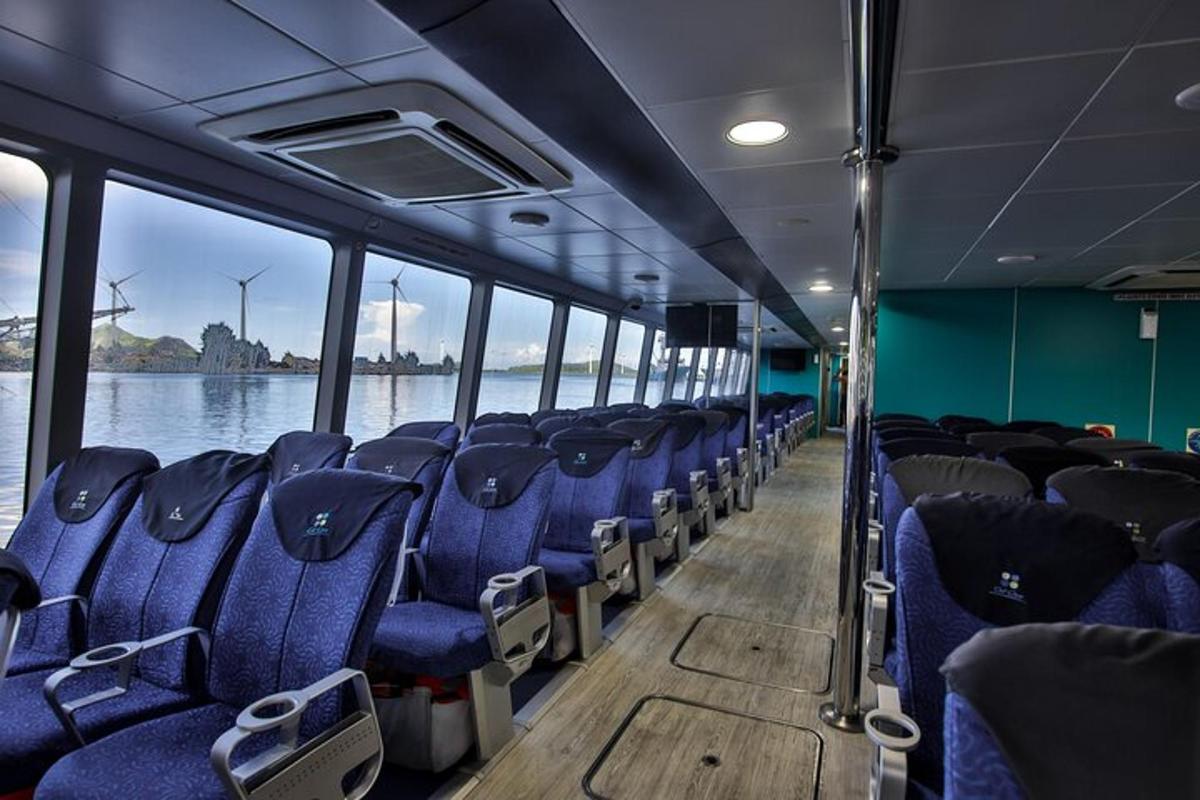 an empty bus with blue seats on the water