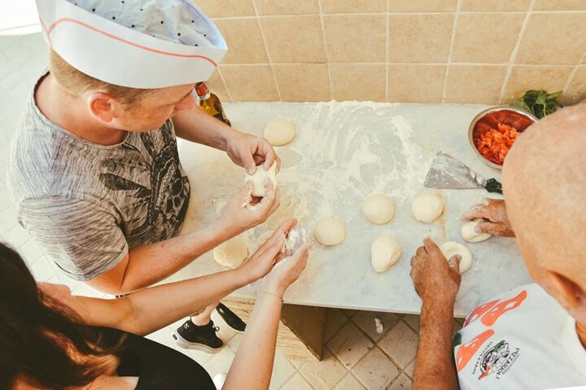 muž a dvě ženy dělají těsto na pultu