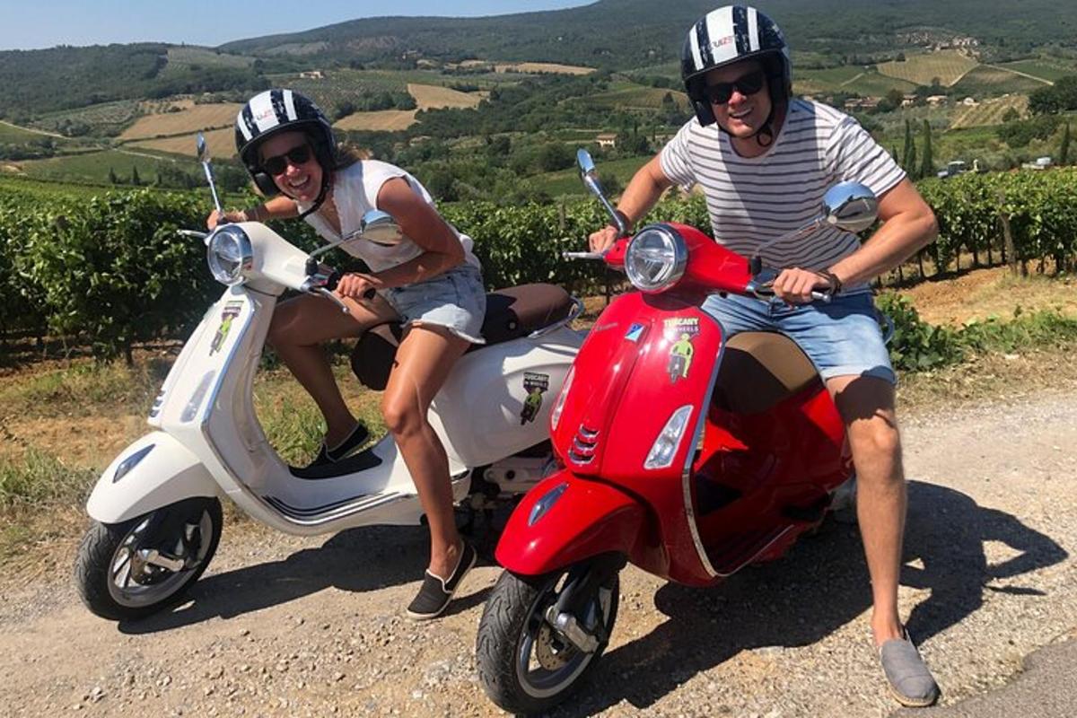duas pessoas sentadas em uma scooter em uma estrada