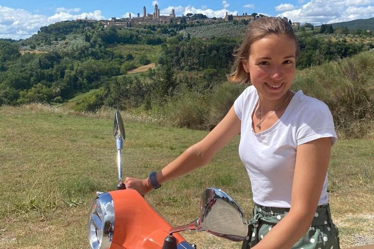 Mladá dívka stojí na oranžové motorce