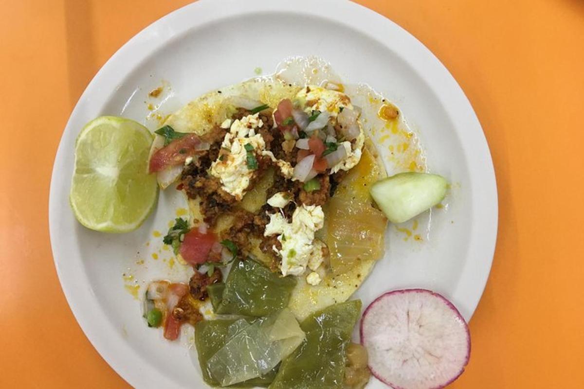 un piatto bianco di cibo con un taco e verdure