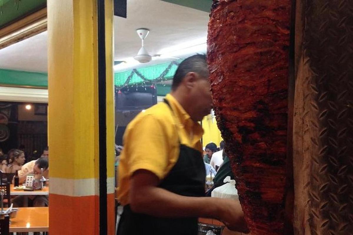 un uomo in piedi dietro il bancone di un ristorante