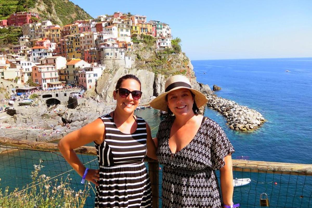 due donne in piedi in cima a una scogliera con una città