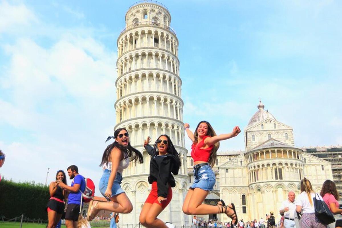 gente saltando frente a la torre inclinada de Pisa