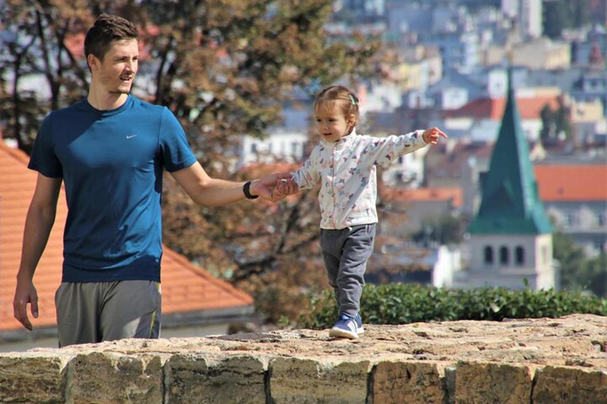 muž a malá holčička stojící na zdi