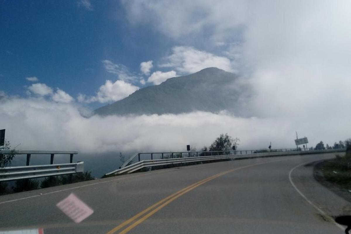 una montagna in mezzo a una strada con le nuvole