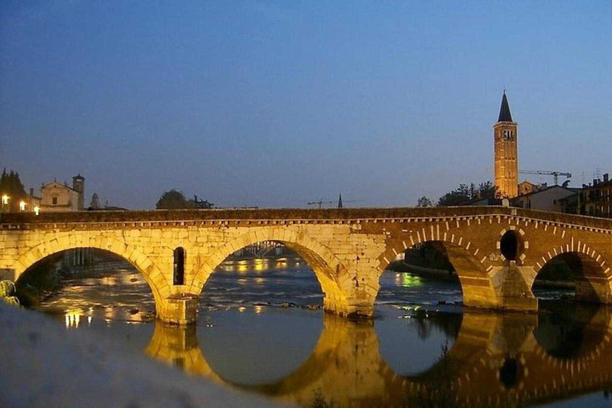 a stone bridge over a river with a clock tower