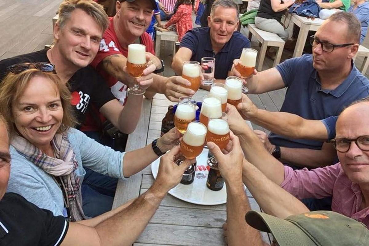 Un grupo de personas sentadas alrededor de una mesa bebiendo cerveza.