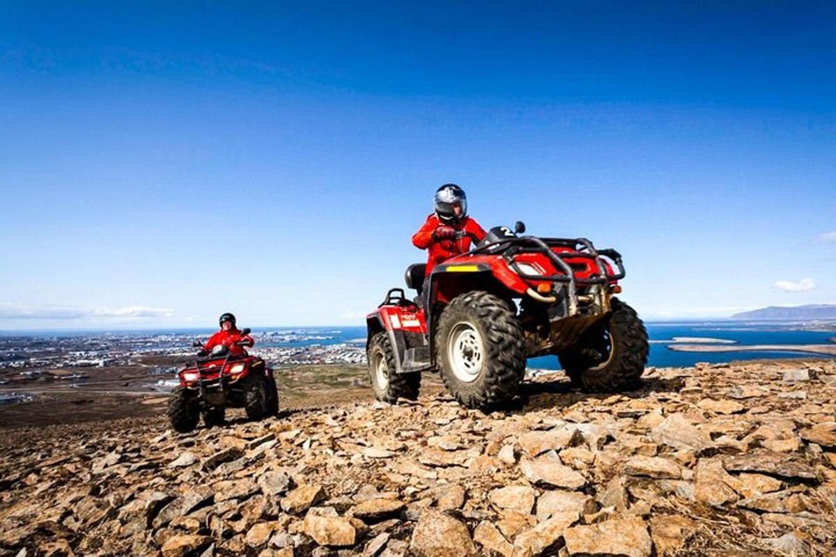 Két ember ül ATV-n egy sziklás dombon