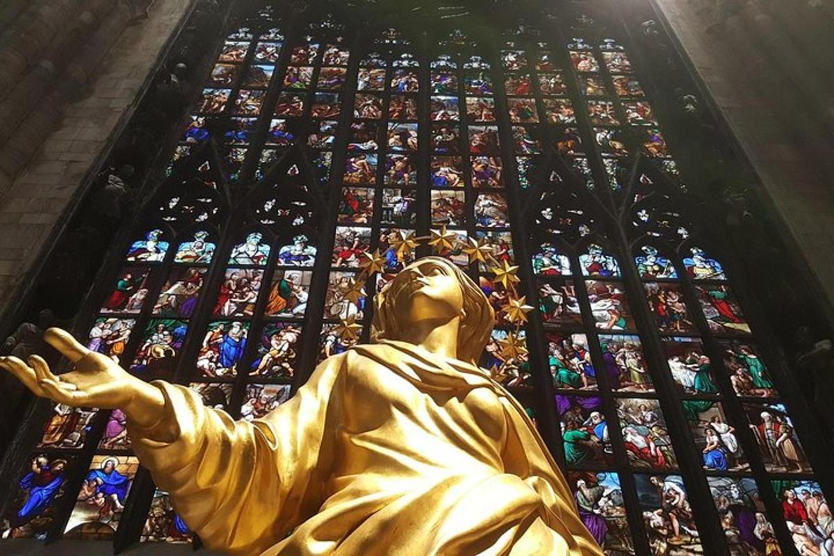 una statua dorata davanti a una vetrata