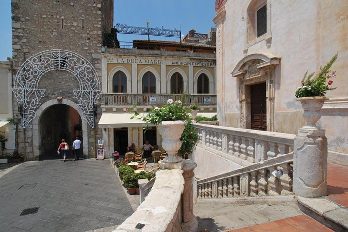 a courtyard of a building with people sitting on a balcony
