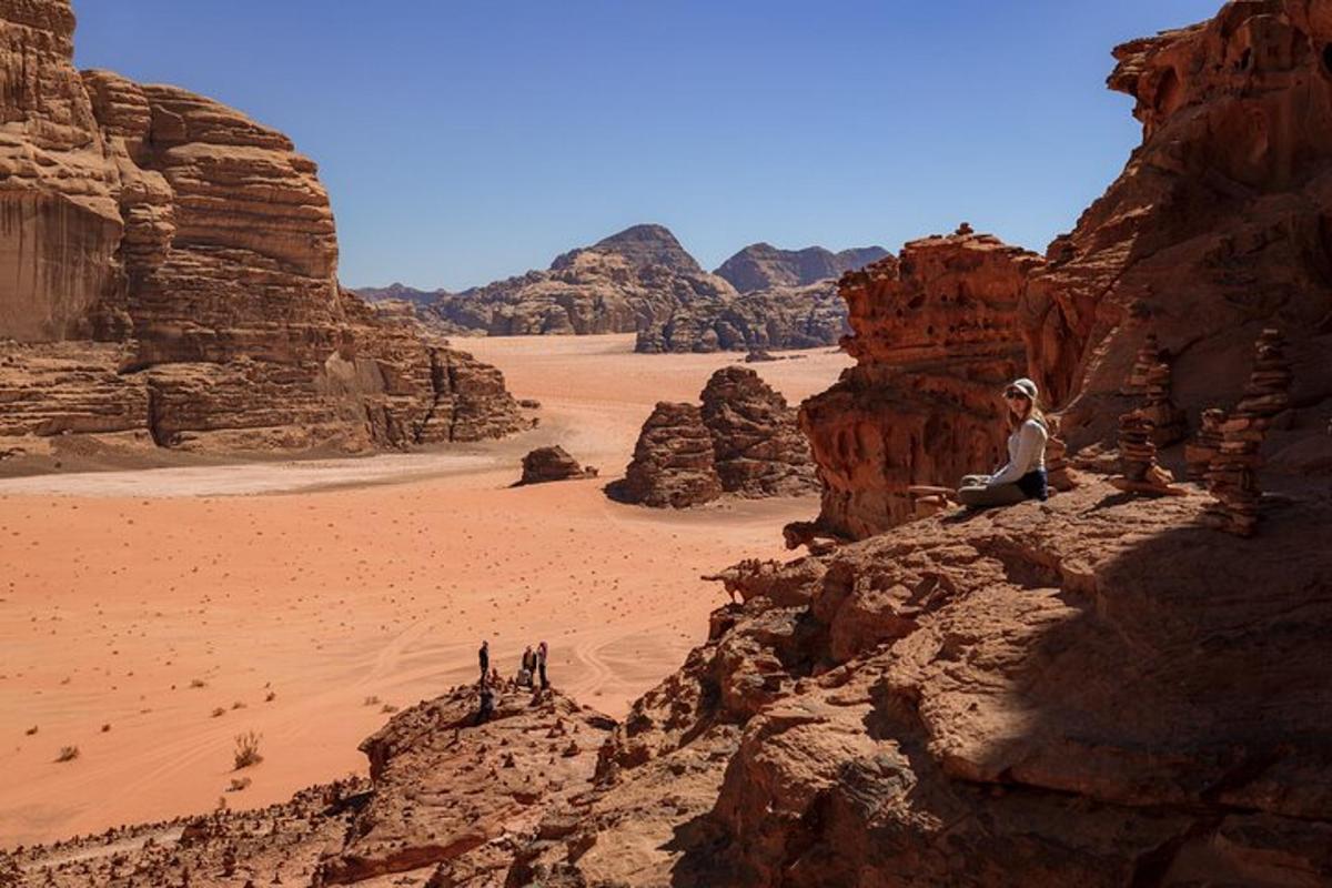 a woman sitting on a rock in the desert